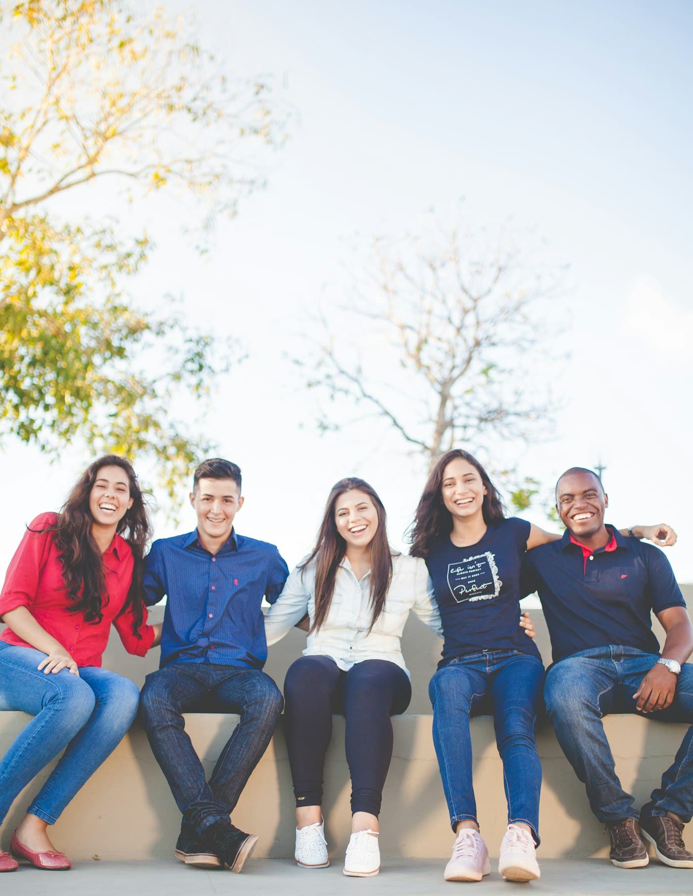 A group of international students sitting together on a campus bench